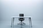 Desk and chair in the center of an empty room